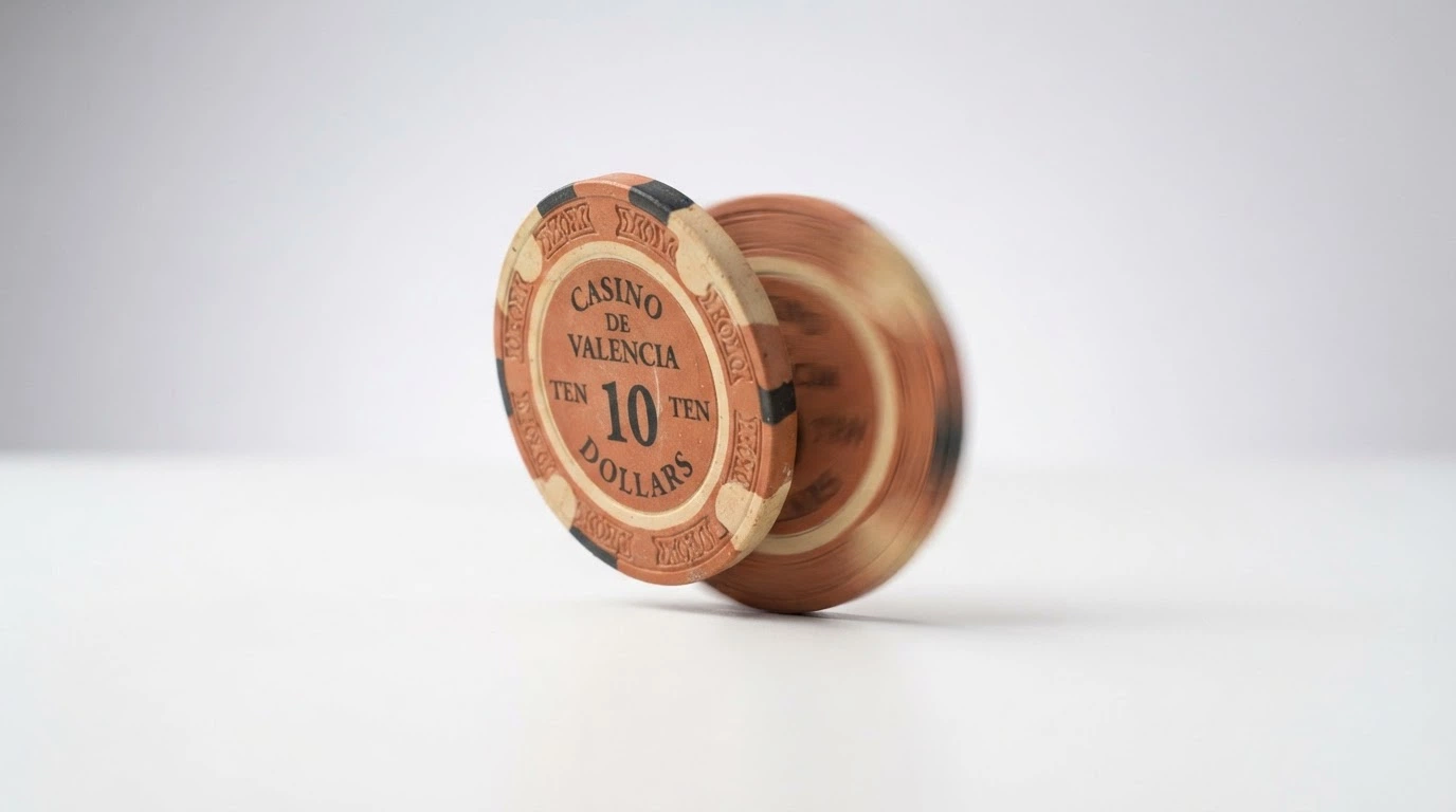 A single Australian one-dollar coin on a plain surface, one side in sharp focus and the other blurred — the coin half-spun